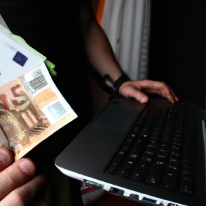 Person holding computer and money